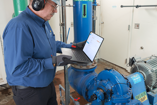 A maintenance technician uses a PRUFTECHNIK vibration monitoring system to screen a machine.