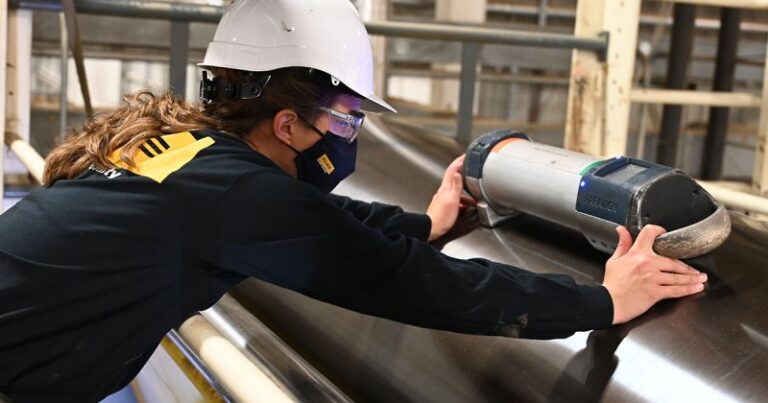 A maintenance technician uses paralign to measure a roll in the plant